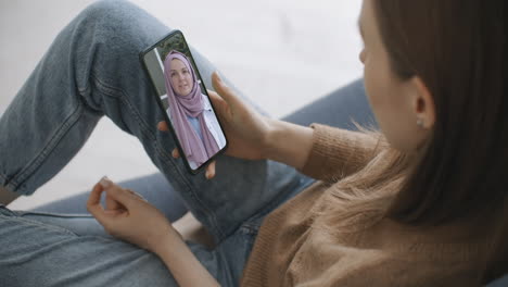 Woman-using-medical-app-on-smartphone-consulting-with-doctor-via-video-conference.-Female-using-online-chat-to-talk-with-family-therapist-and-checks-possible-symptoms-during-pandemic-of-coronavirus.